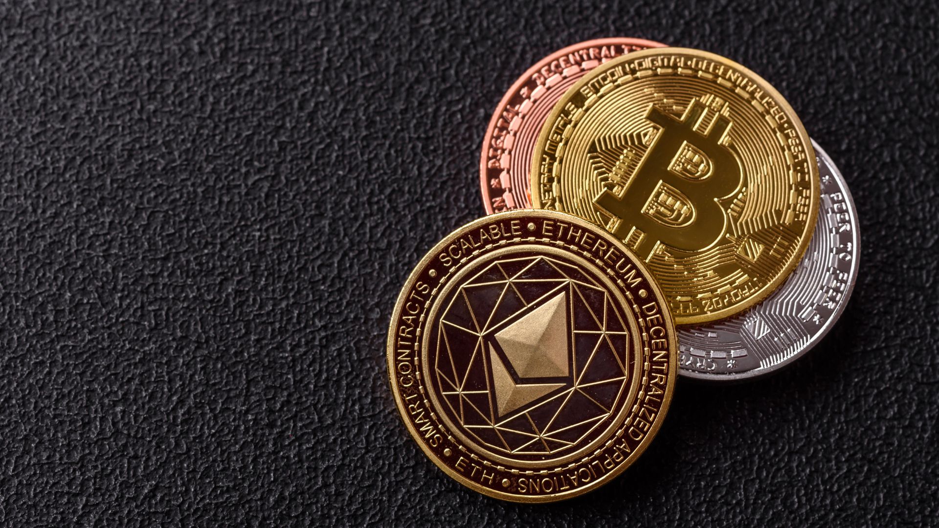 Bitcoin and Ethereum cryptocurrency coins on a dark textured background