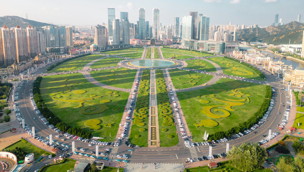 an aerial view of xinghai square with green grass in Dalian